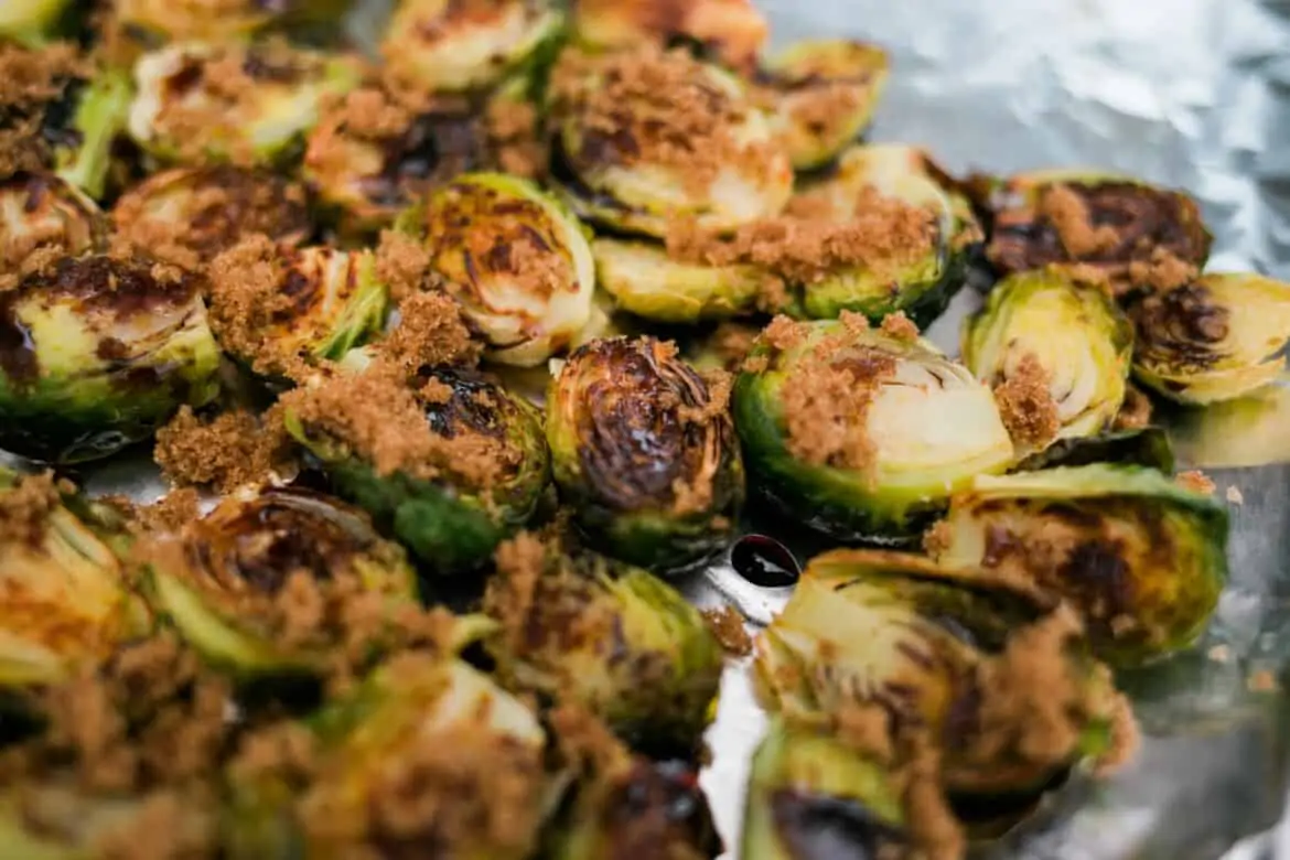 brown sugar sprinkled on top of oven baked Balsamic Glazed Brussels Sprouts Recipe