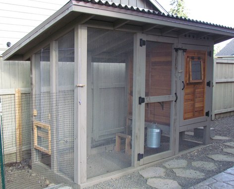 A wooden, fenced in chicken coop with steel roof Free DIY Chicken Coop Plans