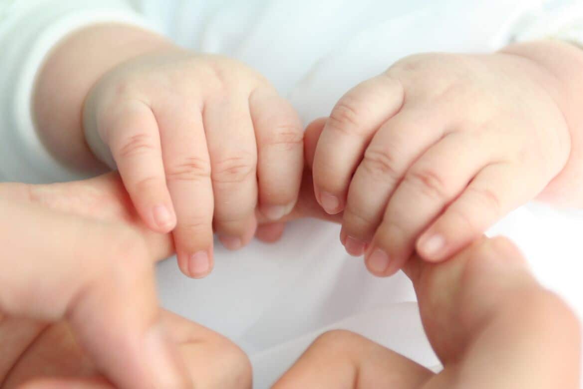 baby hands holding adult fingers