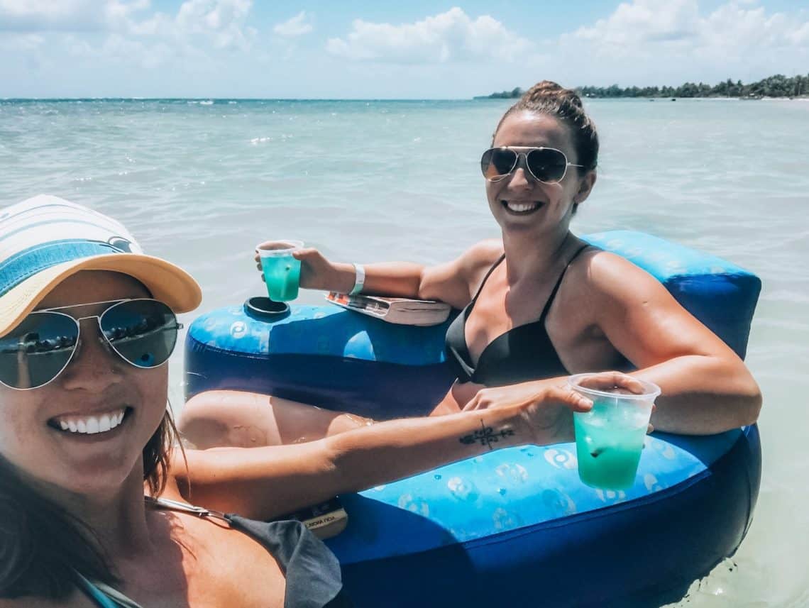 girls floating in ocean with drinks 2