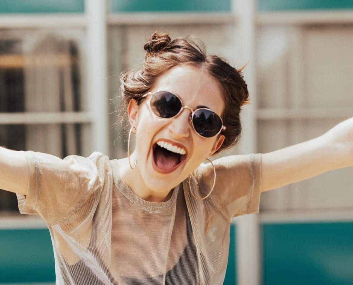 happy woman in sunglasses - self care tips for moms