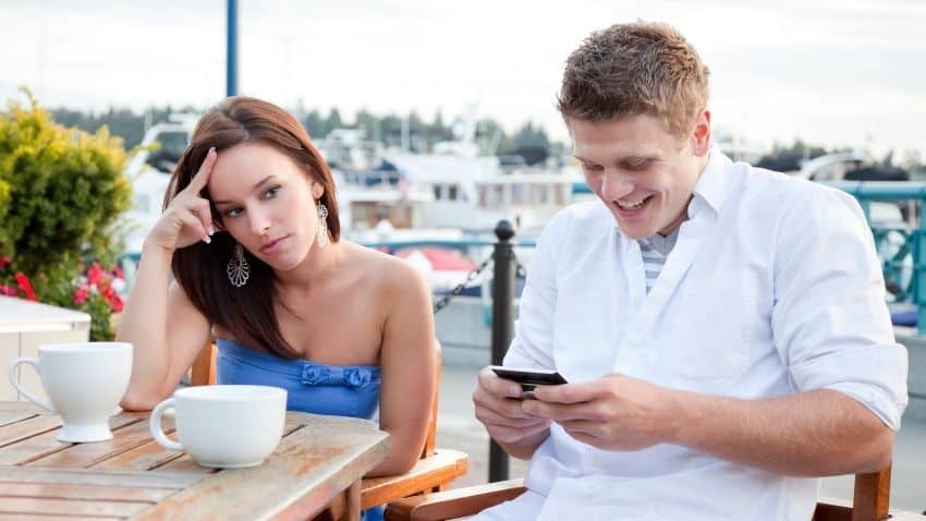 bad first date guy is on phone and girl looks annoyed
