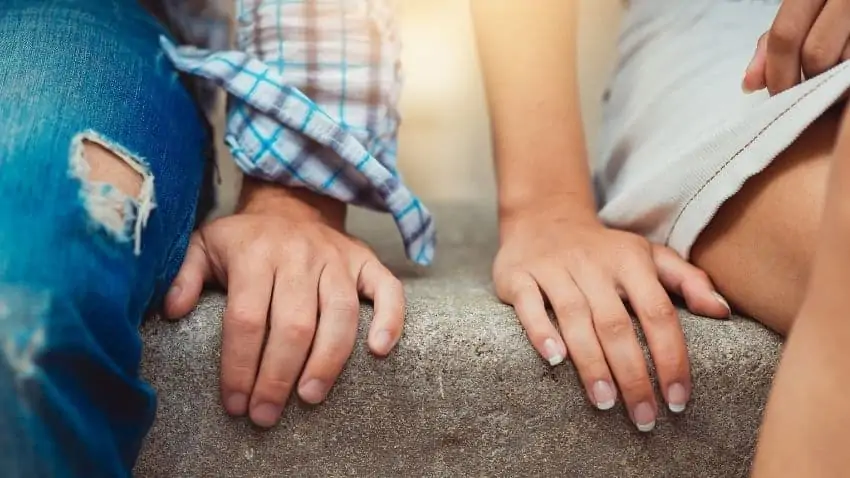 man and woman sitting with hands close