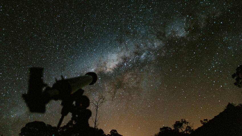 telescope with milky way in background