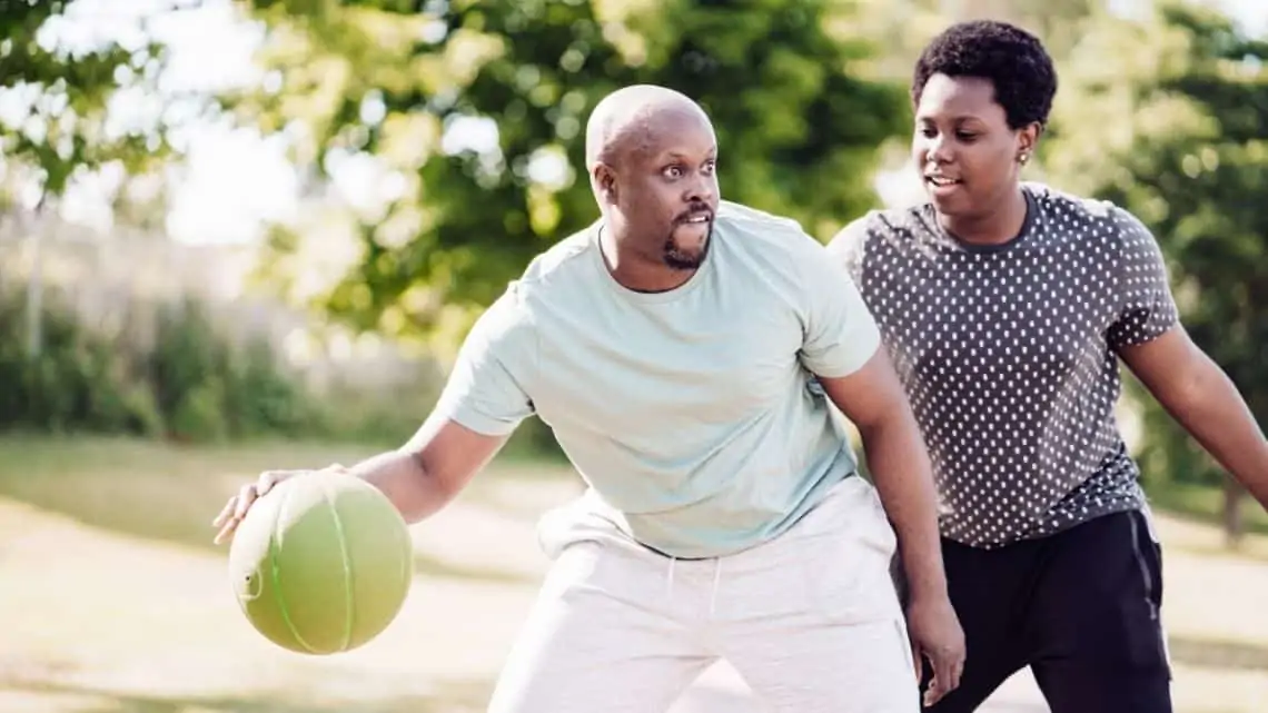 parent bonding woth teen playing basketball