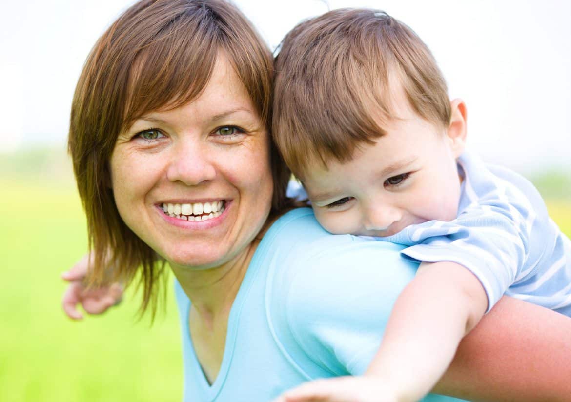 Mother is playing with her son outdoors